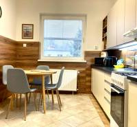 A kitchen in a 3-room apartment with a dining table, floor with wood decor.