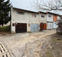 Garages on Prachatická Street in Zvolen with the real estate agency's sign.