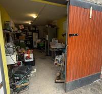 An open garage full of various items and posters in the garage on Prachatická Street in Zvolen.