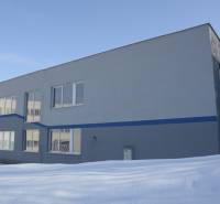 Building on Trenčianska Street in Nová Dubnica. Warehouses and halls covered in snow.