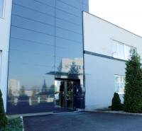Entrance to the building on Trenčianska Street in Nová Dubnica surrounded by greenery. Warehouses and halls.
