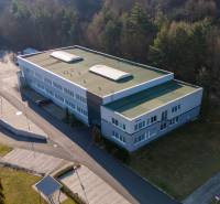 Warehouses and halls on Trenčianska Road in Nová Dubnica surrounded by forest from a bird's eye view.