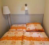A bed in a cabin with orange-beige bedding and reading lamps.