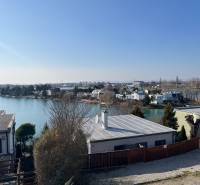 View of the Cottages at Sunny Lakes in Senec surrounded by water and greenery.