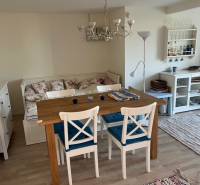 Dining area in the cabin with a wooden table, chairs, and a sofa, floor with a wooden decor.