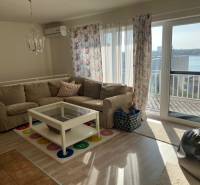 Living room with a sofa, coffee table, and floral curtains in a cottage.
