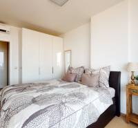 Bedroom in a 3-room apartment with a double bed, white wardrobe, and wood-patterned flooring.