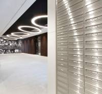 A stylish entrance hall with mailboxes, circular lights, and creative wall art.