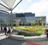 A modern building with a grassy area and people on Landererova in Bratislava - Staré Mesto.
