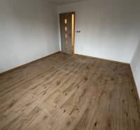 A room in a family house with a wooden floor decor and light-colored walls.