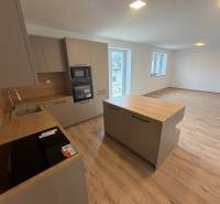 A kitchen in a family house with a wooden decor floor, bright and spacious layout.