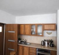 A kitchen in a family house with wooden cabinets and a countertop.