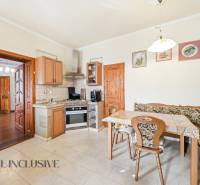 A kitchen with built-in appliances and a dining table in the interior of residential plots.