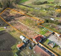 A plot of land in the village of Vrakúň for residential purposes, with fruit trees and buildings in the corner.