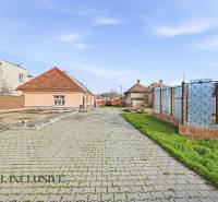 Paved access road leads to houses, plots - housing in Vrakúň.