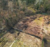An aerial view of overgrown residential plots in Vrakúňa, bordered by forest.