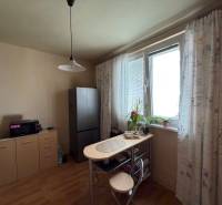 Dining nook with a window and a wooden decor floor in a 3-room apartment.