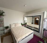 A bedroom in a 3-room apartment with a large built-in wardrobe and a floor with a wooden decor.