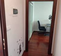 A hallway in a 2-room apartment with wall decor and a floor with a wood design.