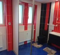 A bathroom with colorful tiles and a sink in a 2-room apartment.