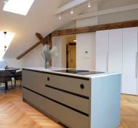 The kitchen in the 3-room apartment features a cooking island, a floor with a wooden decor, and a dining table.