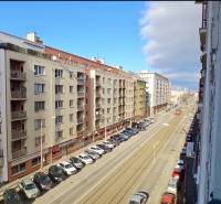 A view of a city street in Bratislava - Old Town with tram tracks and parked cars.