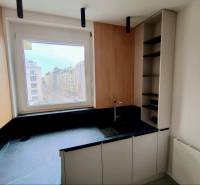 Kitchen in a 2-room apartment with a view of the city, floor with wood decor.
