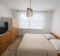 A bedroom in a 3-room apartment with wooden furniture and a floor with a wooden decor.