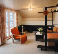 Living room with an orange armchair and sofa in a family house.