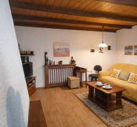 A living room in a family house with a wood-patterned floor, a comfortable couch, and decorations.