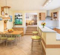Kitchen and dining room with a bar in a family house, light shades and an aquarium.