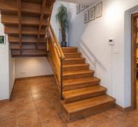 Staircase with a wooden decor floor in a family house, leading to the dining room.