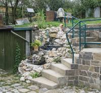 The exterior of a family house on Mieru Street in Poproč, with a staircase and floral decorations.