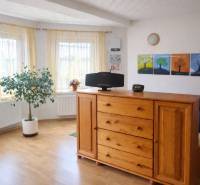 Bright room in a family house with wooden decor, a dresser, and a houseplant.