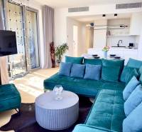 Living room with a turquoise sofa, round table, and wooden decor flooring.