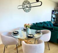 Dining table in a 3-room apartment with a round glass top and four chairs.