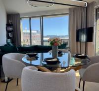 Dining area in a 3-room apartment with a round table and large windows.