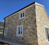 A family house in the town of Vrsi on Vrsi Street with a stone facade and white windows.