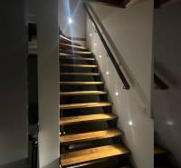 Wooden stairs in a family house with LED lighting installed along the wall.