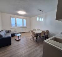 Interior of a 2-room apartment with a wooden decor floor, sofa, and dining table.