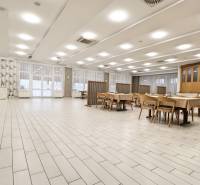 Spacious commercial spaces with wood-decor flooring and arranged tables and chairs.