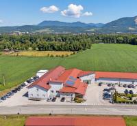 Commercial premises on Uhrovecká Street in Lednické Rovne with a parking lot and surrounding landscape.