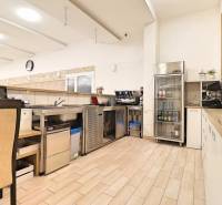 Commercial premises with a bar, open refrigerator, and floor with wooden decor.