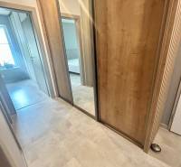 A hallway with a wooden decor floor and a built-in wardrobe in a 2-room apartment.