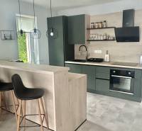 A kitchen corner with dark furniture and decorative lighting in a 2-room apartment.