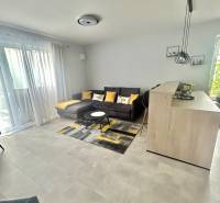 Living room with a sofa, table, and light-colored walls in a two-room apartment.