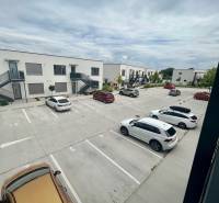 Parking lot on Golfová Street in Hrubá Borša in front of 2-room apartments, several cars parked.