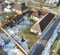 Plots for residential use in Zemné with snow-covered roofs and a garden bordered by an orange line.