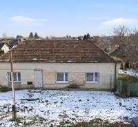 A family house in Zemné with a shabby facade, snow cover on the property - living.