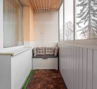 Glazed loggia with a wooden decor floor in a 3-room apartment.